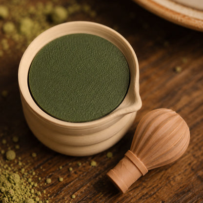 Kuma Labs Matcha Bowl Clicker — flat lay beside matcha cup