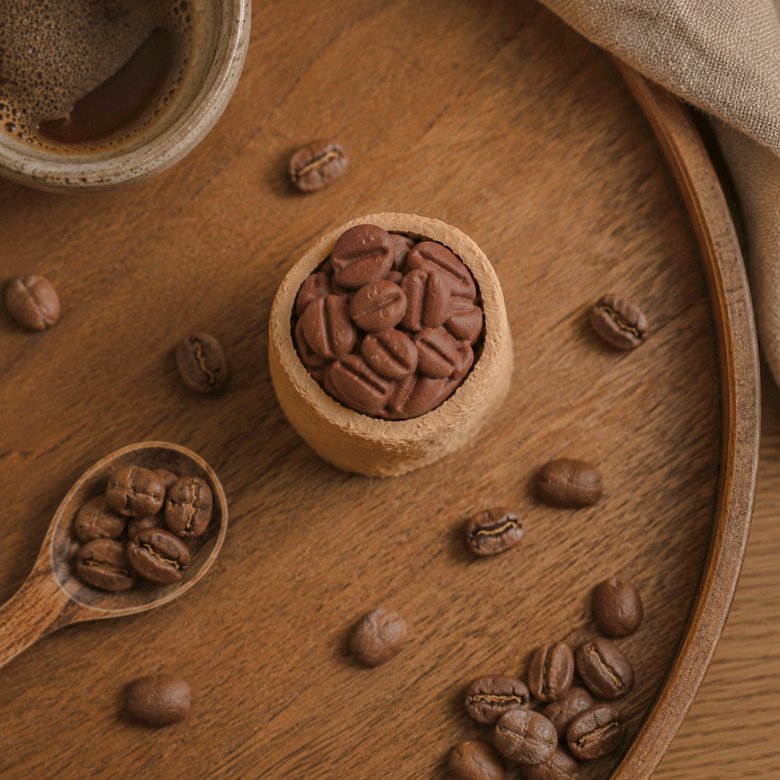 Kuma Labs Coffee Sack Clicker — lifestyle photo beside coffee cup